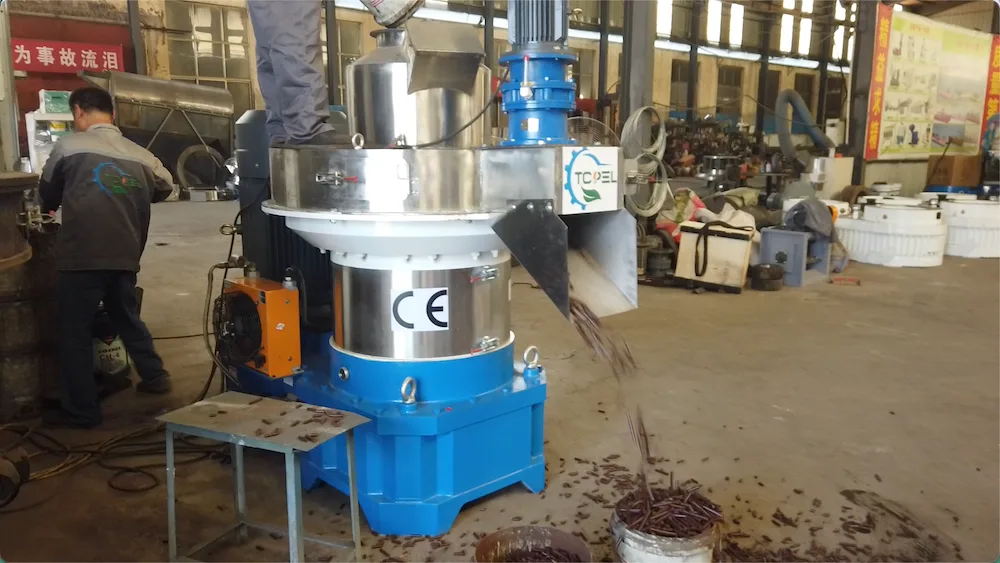 Material discharging from a TCPEL vertical ring die pellet mill